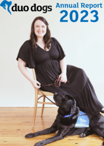 A Duo client with their assistance dog. text: Duo Dogs Annual Report 2023